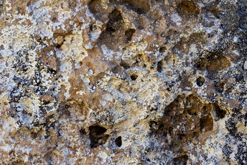 Texture of old stone wall. Brown surface with cracks, holes,stains.