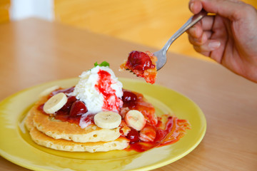 Buttermilk pancake filled with sliced banana and strawberries