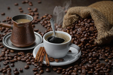 Coffee in a cup on a background of coffee beans, on an old background.