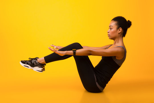 African American Woman Doing Abs Exercise With Leg Raise, Studio