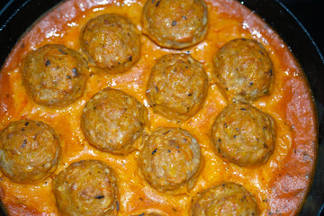 Delicious baked meatballs in the oven. Cooked in a creamy sauce. Selective focus.