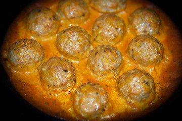 Delicious baked meatballs in the oven. Cooked in a creamy sauce. Selective focus.