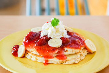 Buttermilk pancake filled with sliced banana and strawberries