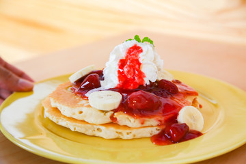 Buttermilk pancake filled with sliced banana and strawberries