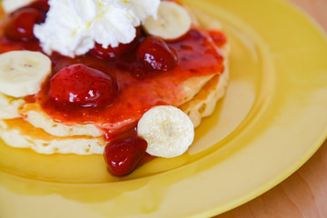 Buttermilk pancake filled with sliced banana and strawberries