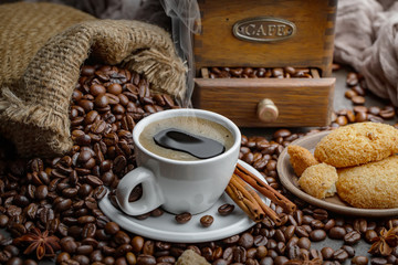 Coffee in a cup on a background of coffee beans, on an old background.