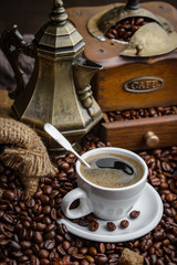 Coffee in a cup on a background of coffee beans, on an old background.