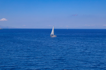Small sailboat in the blue ocean water.