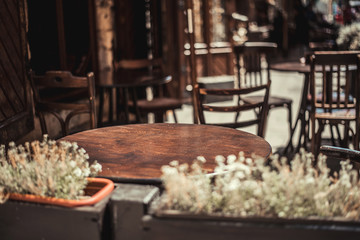 View of old cozy cafe in old city. Wooden tables and chairs in an outdoor cafe
