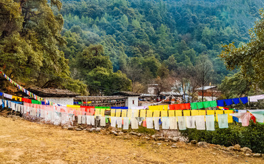 Traditional prayer Tibetan Buddhist flags Lung Ta and ancient buildings of Monastery high in the Himalayan mountains in Bhutan.