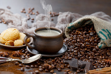 Coffee in a cup on a background of coffee beans, on an old background.