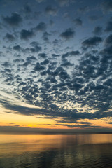 Amazing sunset or sunrise landscape. Great perfect cloudy colourful sky, golden horizon line and shiny peaceful surface of sea water. Vertical color photography of nature of Tunisia country.