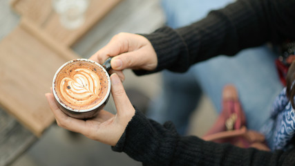 Fototapeta premium Coffee latte heart texture in hand of tourists.