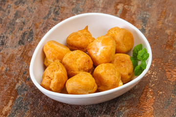 Sweet tasty profiteroles heap in the bowl