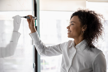 African American woman busy developing business strategy on board