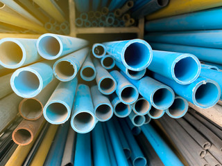 Metal pipe stainless and blue plastic pipe stacked in store