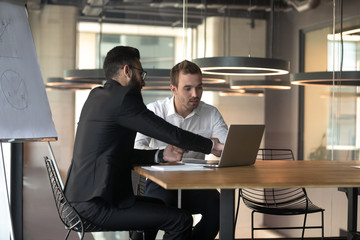 Diverse businessmen coworking at office briefing using laptop