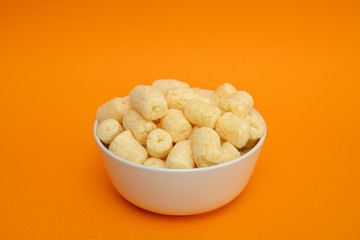 Crunchy sweet corn sticks with powdered sugar in white bowl