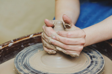 Woman hands on pottery wheel. Craftsman artist shapes pot