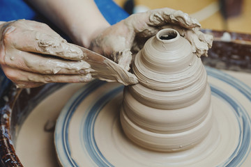 Woman hands on pottery wheel. Craftsman artist shapes pot