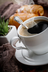 Coffee in a cup and saucer on an old background.