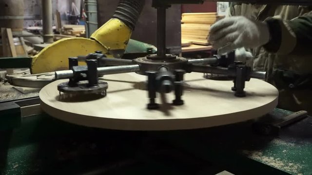 Making a wooden lid for a wine barrel on a modern woodworking machine in a cooper
