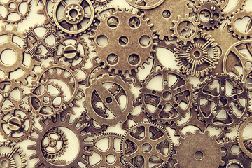 Background of vintage gears over wooden table, Aged mechanical clock wheels