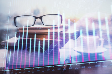 Financial graph hologram with glasses on the table background. Concept of business. Double exposure.