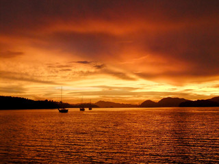 Naklejka premium Sunrise with Sailboat in silhouette