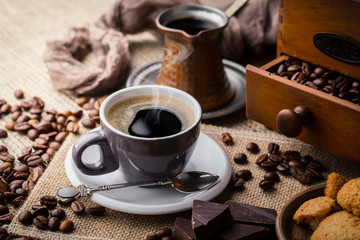 Coffee in a cup and saucer on an old background.