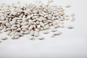 White raw beans sprinkled on a white background. Copy spaes. horizontal