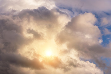 Fototapeta na wymiar Dramatic epic cumulus fluffy white clouds with sun and sunlight, heaven