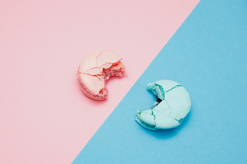 Minimalism, bitten macaroons on pink background, top view. Concept reducing interest rates on loans...