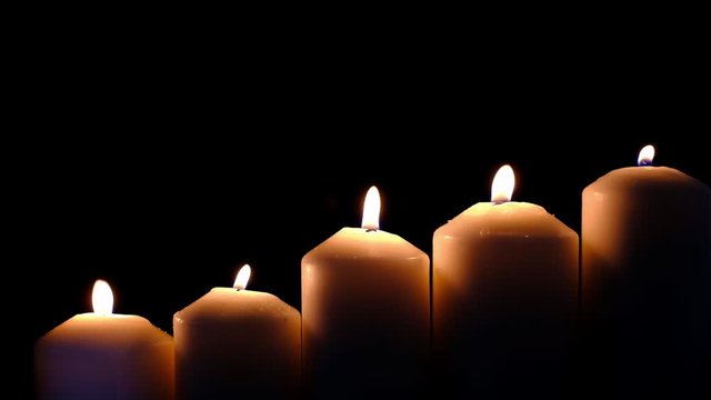 light flame candle burning brightly on black background