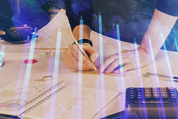 Double exposure of man writing on paper with forex graph.