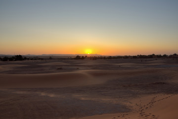 Last sickle of the setting sun above the mountains seen from Erg Chebbi
