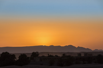 Last rays of light of the setting sun above the mountains seen from Erg Chebbi