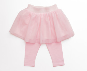 Tulle pink skirt and pants for toddler girl on white background/ Top view/ Baby clothes 