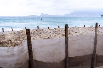 Plage de sable de Saint-Cyr-Sur-Mer en hiver avec surfeurs et récupération du sable