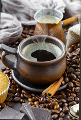 Black coffee beans roast in a pan in the smoke