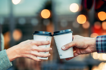 a couple is toasting with paper cup and drink coffee - 308217949