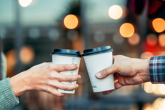 A Couple Is Toasting With Paper Cup And Drink Coffee