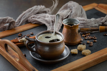 Black coffee beans roast in a pan in the smoke