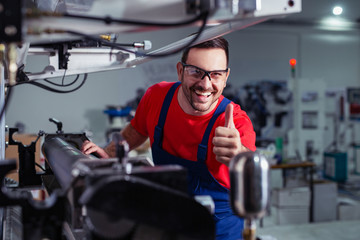 Industrial worker thumb up in factory.