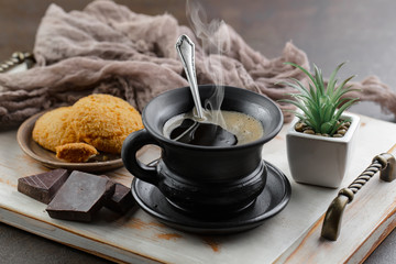 Black coffee beans roast in a pan in the smoke