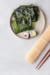Nori sheets and sushi maki on concrete table. Top view. Vertical photo. Copy space.