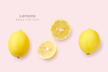  Overhead image with whole lemons and lemon slices on pink background. Copy space