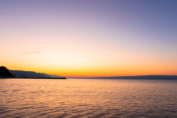 Dark beach at a sunrise with golden white orange sky. Beach in split,croatia