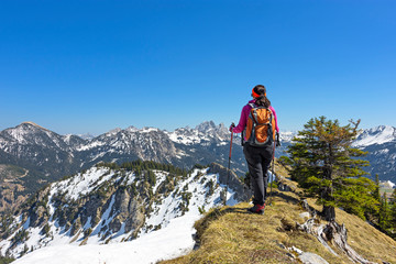 Fototapeta premium Female hiker walking in alpine landscape in spring. Allgau Alps, Tirol, Austria. Copy space