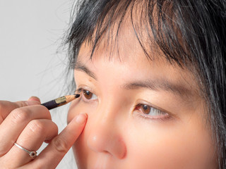 Obraz premium Femme asiatique se maquillant les yeux
